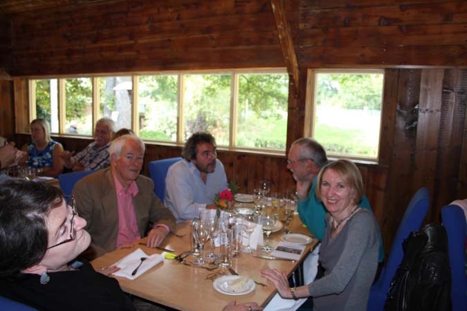 Staff sitting around a table a reunion at Dedham Boat House. 
