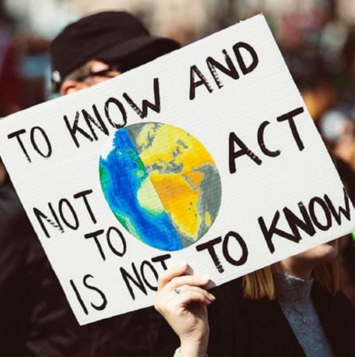 Student protest sign, which reads 'To know and not to act, is not to know.