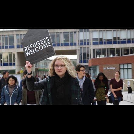 Students with a sign that reads 'Refugees welcome'