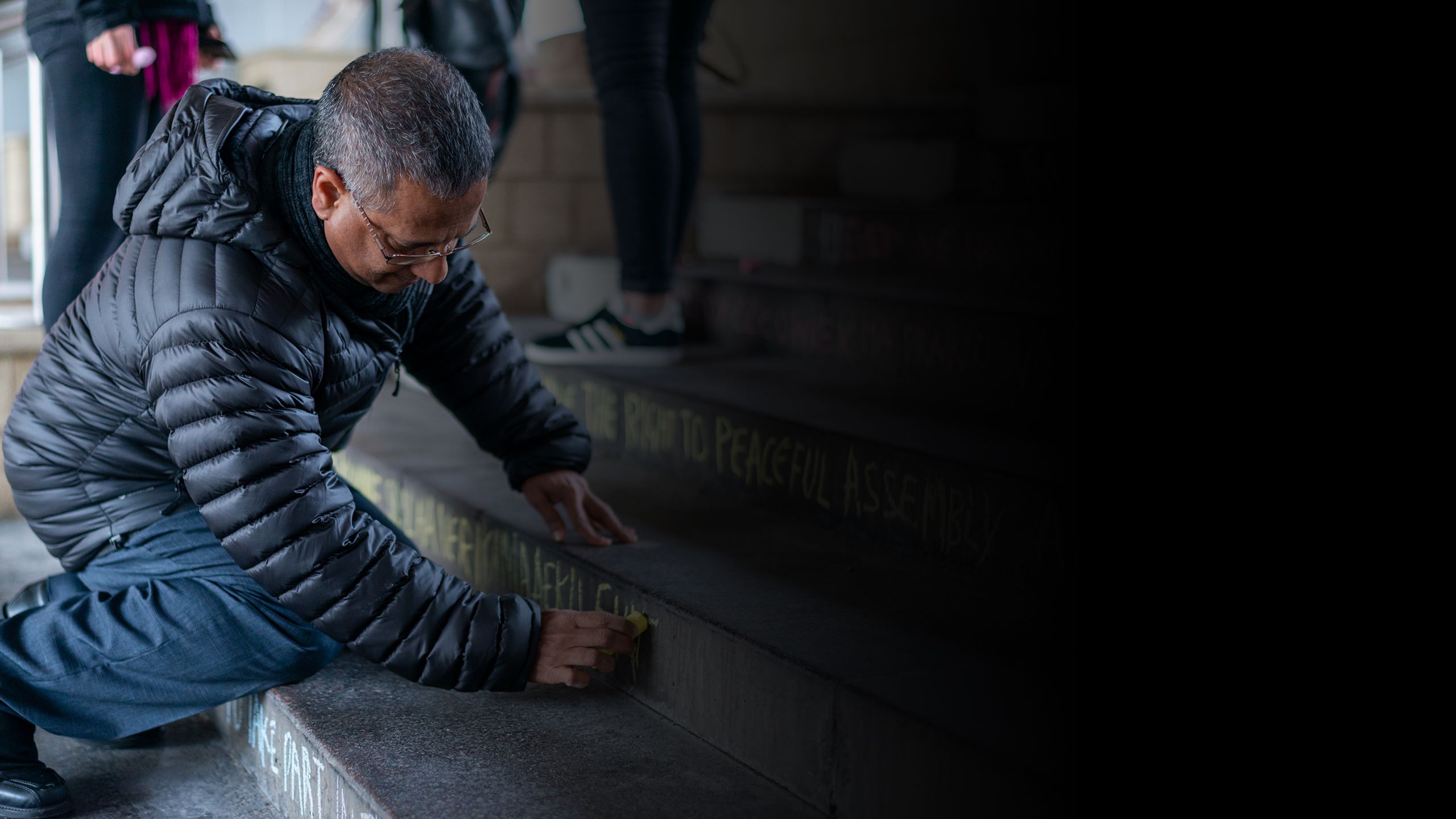 Professor Ahmed Shaheed chalking the steps on the University of Essex Colchester campus as part of Human Rights Day