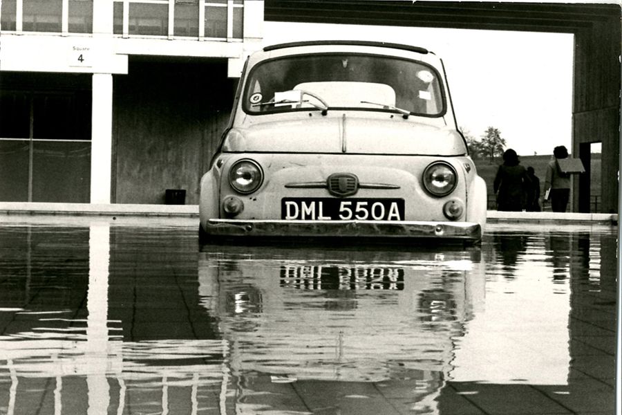 A black and white photo showing an old Fiat 500 car parked in a fountain on our Colchester Campus.
