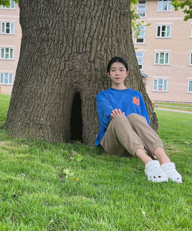 Lurui Xie sitting in front of a tree