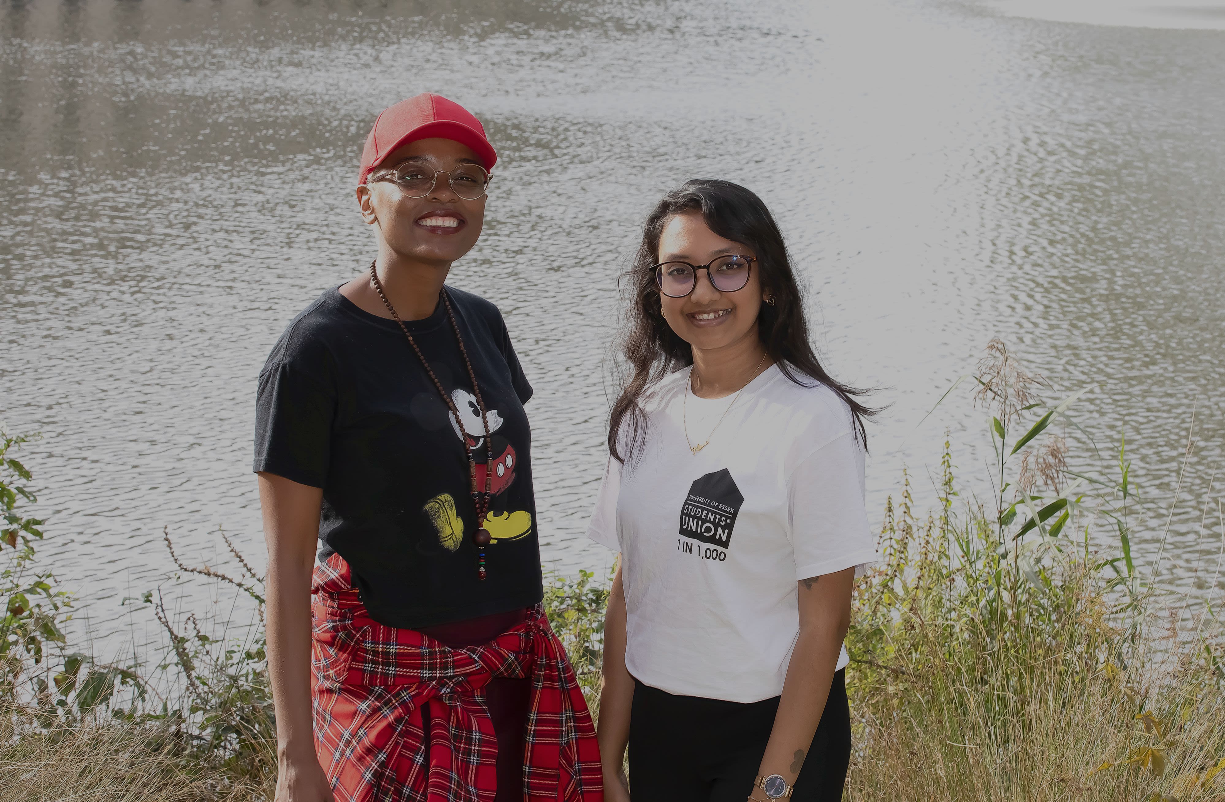 Naomi Gumede and Nilisha Subasinghe standing in front of the lakes on our Colchester Campus